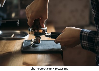 Female barista tamping coffee in a portafilter - Powered by Shutterstock