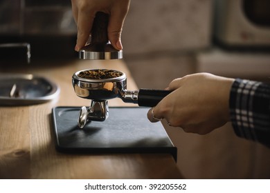 Female barista tamping coffee in a portafilter - Powered by Shutterstock