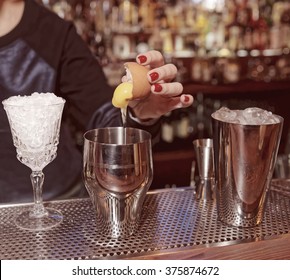 Female bartender is adding egg yolk to the glass, toned
