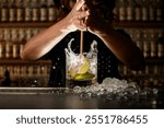 Female bartender energetically inserts a Turbo Swizzle Barta muddler into a glass with a cocktail