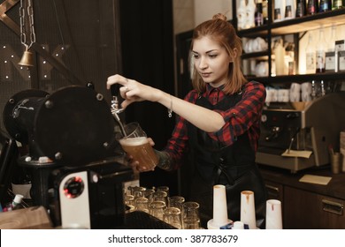 Female Bartender Pouring Beer At Bar