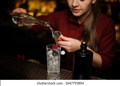 Female Bartender Pouring Gin Into A Cocktail Glass For Making A Bitter Fresh Summer Drink