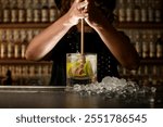 Female bartender uses a Turbo Swizzle Barta muddler to squeeze lemons directly into a glass with a drink