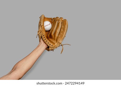 Female baseball gloved hand catches ball. Gray background. Active sport, championship, victory - Powered by Shutterstock