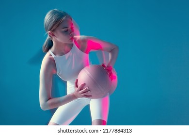 Female basketball player moving holding ball in pink neon light. Long exposure. Copy space. Energetic sports workout - Powered by Shutterstock