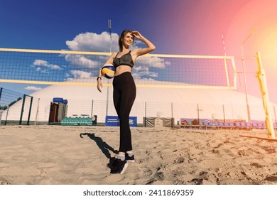 A female beach volleyball athlete with ball on the volleyball court - Powered by Shutterstock