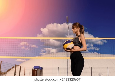 A female beach volleyball athlete with ball on the volleyball court - Powered by Shutterstock