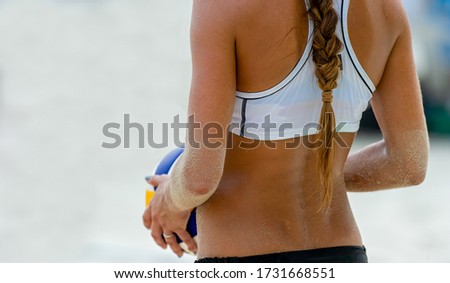 A Female Beach Volleyball Player is Getting ready to Serve the Ball