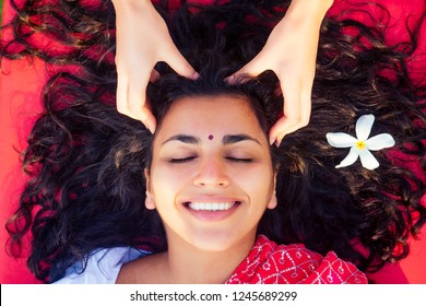 Female Beautician Doctor With Patient Make Procedure To Beautiful Indian Girl.close Up Portrait Of Asian Woman Closed Eyes And White Smile Wellness Head Massaging On Beach.Face Lifting Massage In Spa