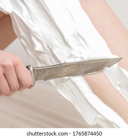 Female beautiful legs of young woman with foam during shaving by knife on white background