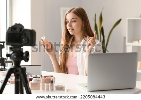 Female beauty blogger with perfume recording video in dressing room