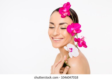 Female Beauty As A Flower. Young Cute Beautiful Smiling Woman With Clean Skin Holds Flowers In Hands On A White Background. Beauty And Spa.