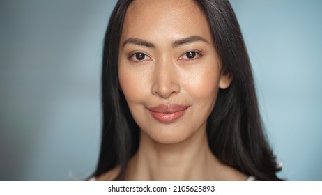 Female Beauty Portrait. Beautiful Diverse Asian Brunette Woman Posing, Smiling, Touching Her Face With Natural, Healthy Skin. Wellness And Skincare Concept On Soft Isolated Background. Close Up.