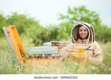 Female Beekeeper With Honey At Apiary