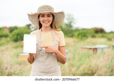 Female Beekeeper With Tablet Computer At Apiary