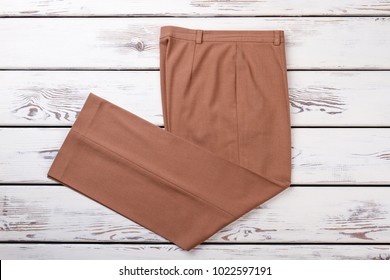 Female Beige Trousers, Top View. Women Formal Pants On White Wooden Background. Female Classic Outfit.