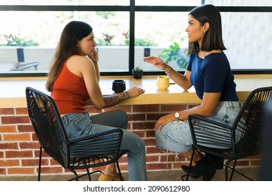 Female Best Friends Catching Up And Having A Deep Conversation. Young Women Talking On A Coffee Shop 