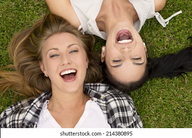 Female best Friends lying on the grass and laughing