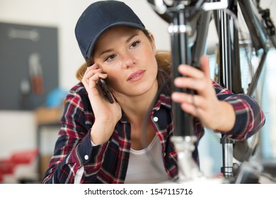 female bicycle mechanic using a smartphone - Powered by Shutterstock