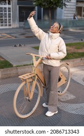 Female Bicyclist Taking Selfie On Street