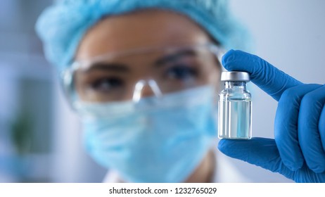 Female biologist holding bottle with new medication, vaccination lab research
