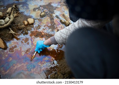 Female Biologist Measuring PH Of Polluted Water