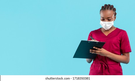 Female Black Doctor Wearing Mask And Writes On Clipboard 