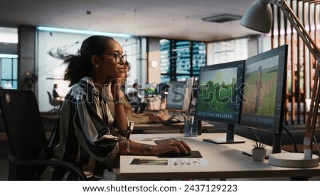 Female Black Game Developer Using Desktop Computer, Designing Unique World And Characters In 3D modelling Software For Adventure Video Game. African Woman Working In Diverse Game Design Studio Office.