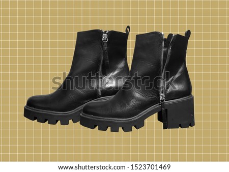 Female black leather boots on thick soles and high heels isolated on checkered brown background. Tractor-soled boots. Fashionable women's boots with a zipper. Women's demi-season shoes