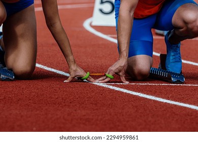 female blind para athlete runner with male guide in starting blocks ready running race, summer para athletics championships - Powered by Shutterstock