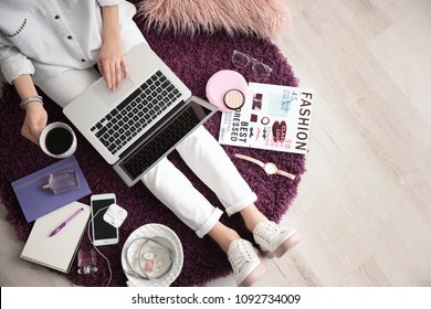 Female blogger with laptop and cup of coffee indoors, top view