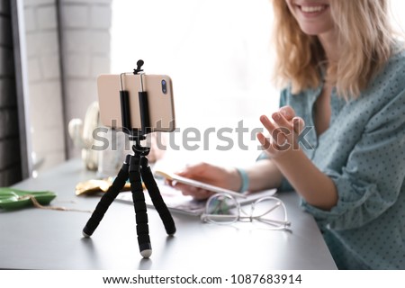 Female blogger recording video at table