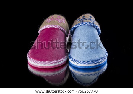 Female blue and pink slipper on black background, isolated product, comfortable footwear.