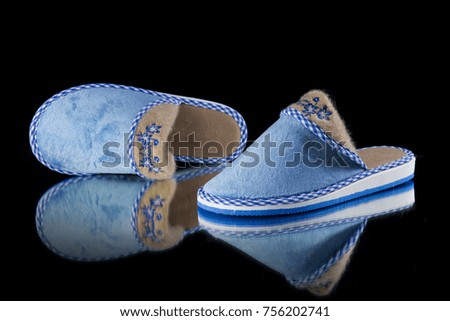 Female Blue Slipper on Black Background, isolated product, comfortable footwear.