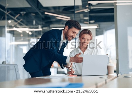 Female boss discussing online project with employee showing presentation to experienced team leader
