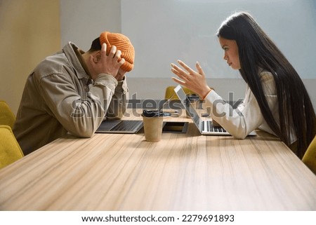 Female boss having difficult conversation with employee in meeting room