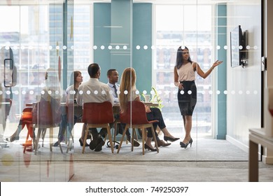 Female boss shows presentation on screen at business meeting