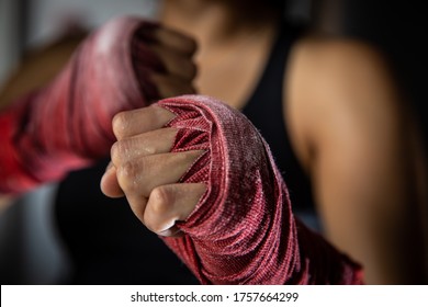 Female boxer close up of fists with red hand wraps - Powered by Shutterstock