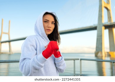 Female boxer in fighting stance staring into the frame, looking in camera powerful and confident women in boxing. Woman fighter, concept of strong woman and self defence. - Powered by Shutterstock