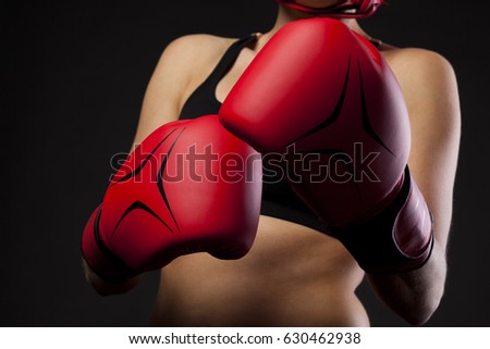 female boxer with read boxing gloves on black background