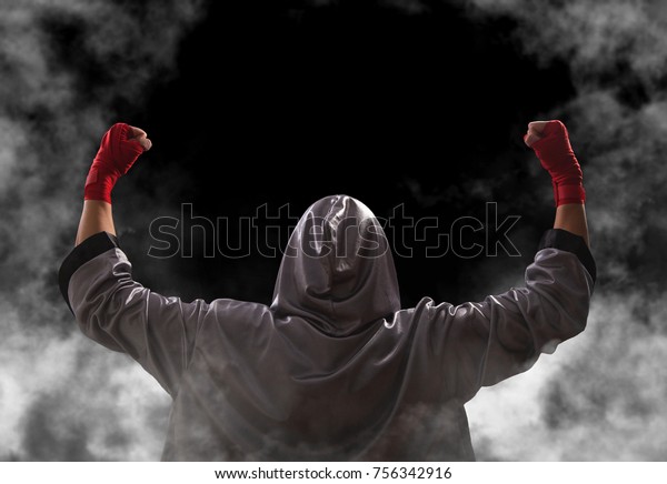 Female\
boxer with red boxing wraps wins the fight and bacame a champion.\
Victory pose. Black background with copy\
space.