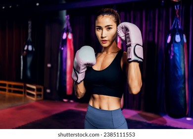 Female Boxer training in Boxing Club. Woman Boxing fighters training at gym. Strong muscular woman practicing box in pink boxing gloves in gym.	 - Powered by Shutterstock