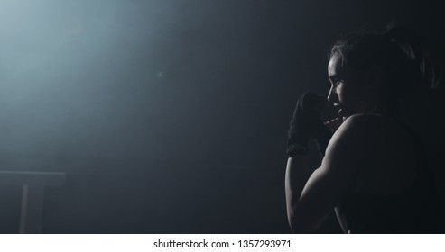 Female boxer training in the dark ring. Slow motion. Silhouette. Boxing concept - Powered by Shutterstock