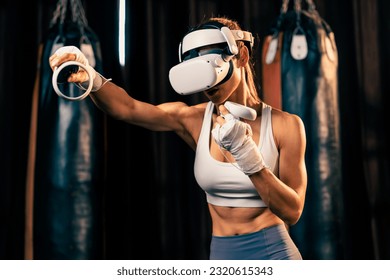 Female boxer training with VR or virtual reality, wearing VR headset with immersive boxing training technique using controller to enhance her skill in boxing simulator. Impetus - Powered by Shutterstock