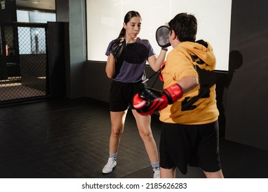 Female Boxing Coach Training A Boy In Gym (boy Punching)
