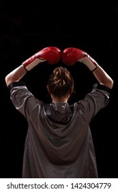 Female In Boxing Robe And Red Boxing Glove On Dark Background.