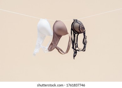 Female bra is hanging on the rope isolated on a light background.