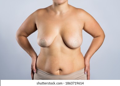 Female breasts, woman with nipple stickers on grey studio background