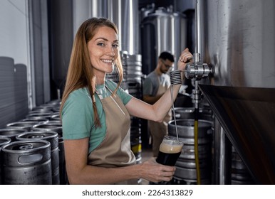 Female brewer working in craft brewery examining quality of the beer. - Powered by Shutterstock