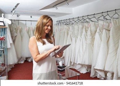 Female Bridal Store Owner Using Digital Tablet